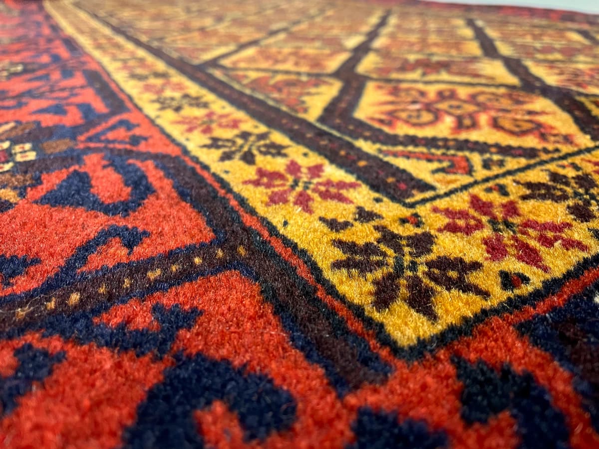 Perserteppich Belutsch, geometrisch, 91x176 cm, überwiegend in Orange und Gelb — Nahaufnahme der Textur
