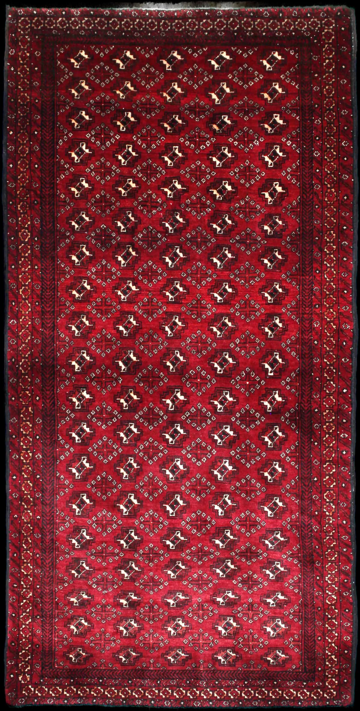 alfombra persa de estilo baluch en dimensiones 218 centímetros de largo por 106 centímetros de ancho con colores principalmente rojo