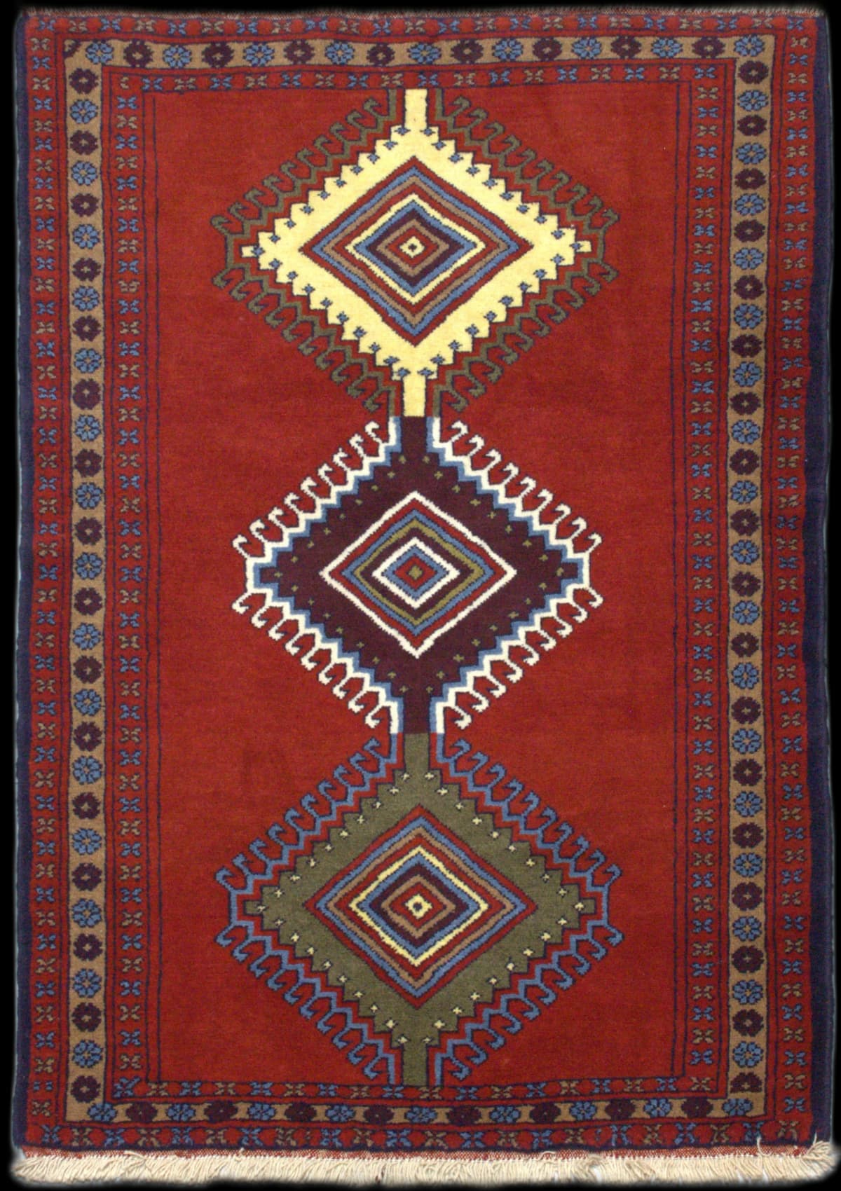 alfombra persa en dimensiones 170 centímetros de largo por 120 centímetros de ancho con colores principalmente rojo