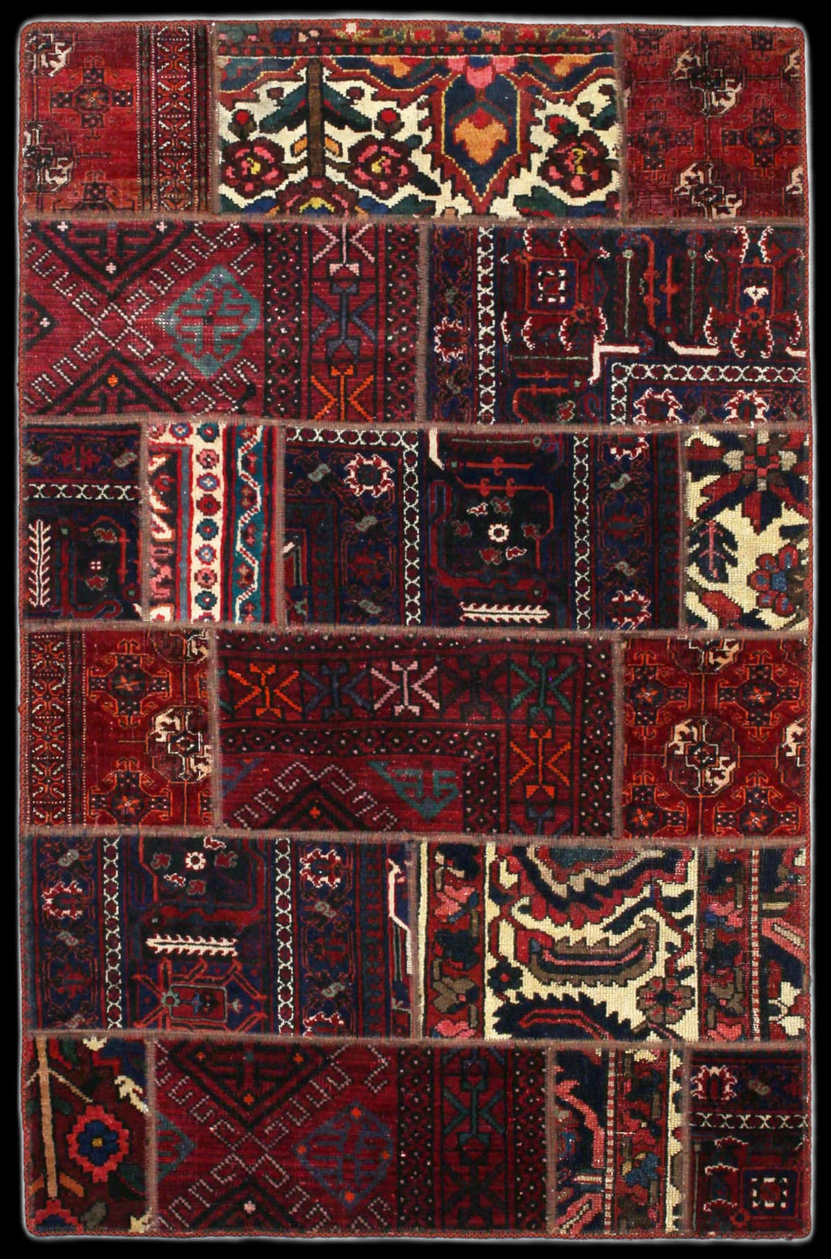 alfombra persa de estilo patchwork en dimensiones 179 centímetros de largo por 116 centímetros de ancho con colores principalmente rojo