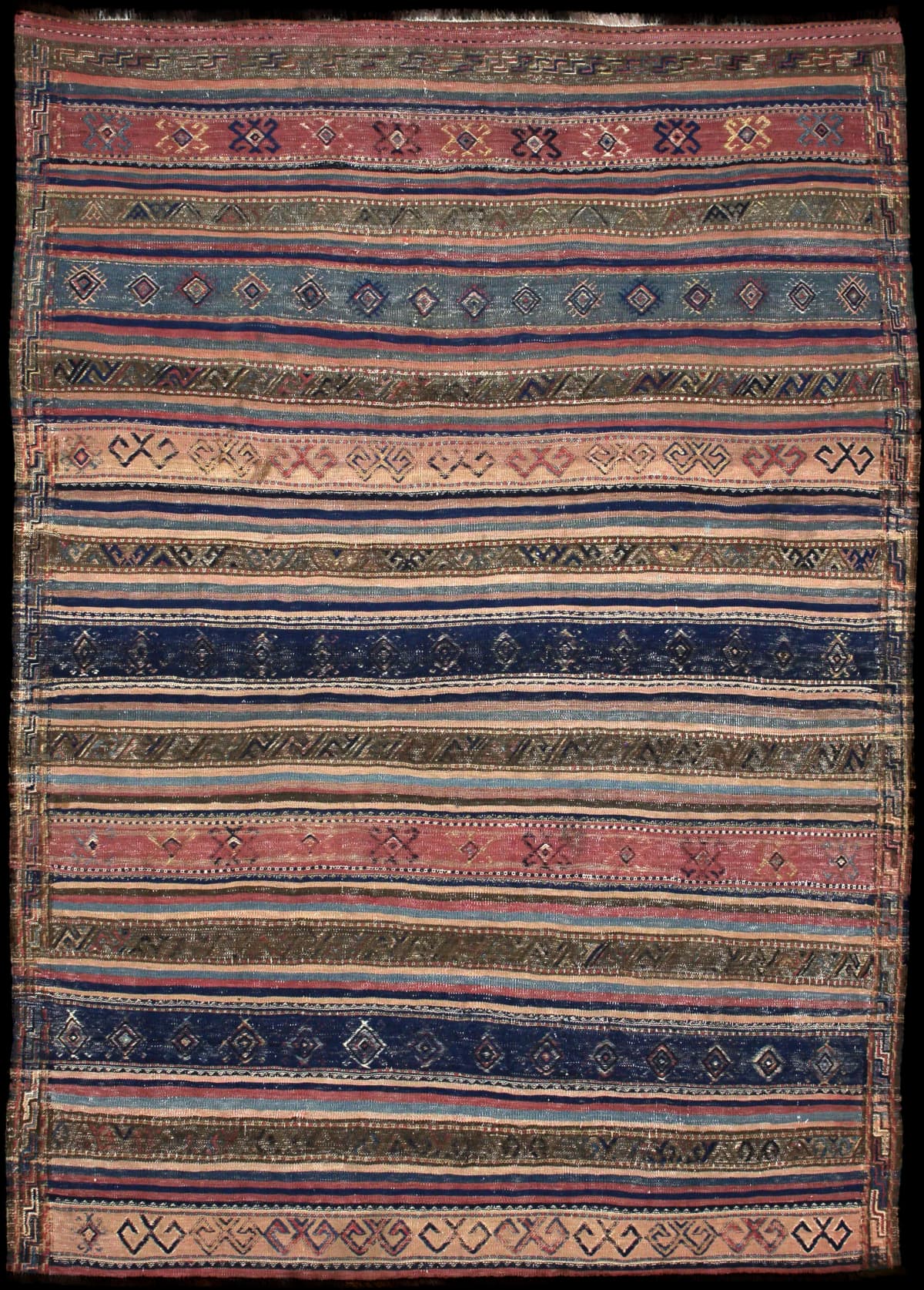 alfombra persa de estilo sumak en dimensiones 245 centímetros de largo por 177 centímetros de ancho con colores principalmente azul y marrón