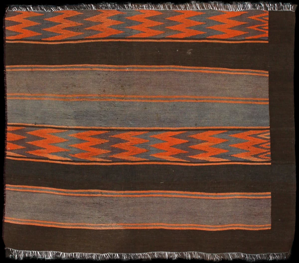 alfombra persa de estilo kilim en dimensiones 137 centímetros de largo por 115 centímetros de ancho con colores principalmente naranja y marrón