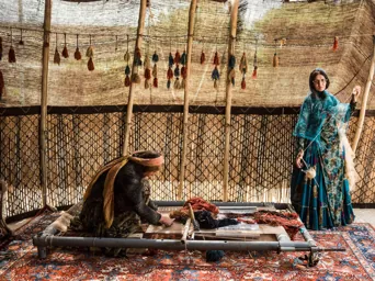 Mujeres nómadas en Irán tejiendo una alfombra persa